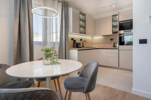 una cucina con tavolo e sedie bianchi di Villa 64 Apartment #1 a Mlini