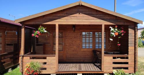 a wooden gazebo with flowers on it at Pas Jūratę namelių nuoma Šventojoje in Šventoji