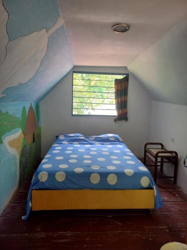 a bedroom with a bed with a painting on the wall at Eco-Cafe El Mirador in Guachaca