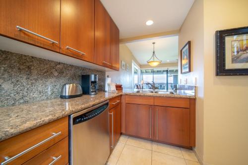 a kitchen with wooden cabinets and a sink at Kapalua Villas Maui - Select Your Unit in Kahana
