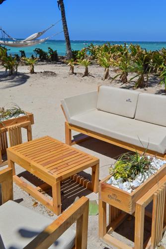 a picnic table and a couch on the beach at Hotel Isla Del Pirata in Isla del Pirata