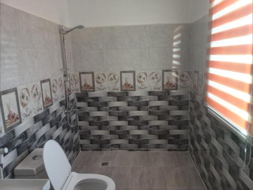 a bathroom with a toilet and a bunch of seats at فيلا بوابة جرش الرومانيه الشماليه in Jerash