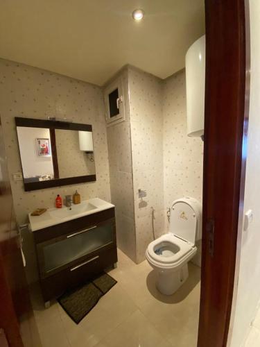 y baño con aseo, lavabo y espejo. en appartement rabat agdal, en Rabat