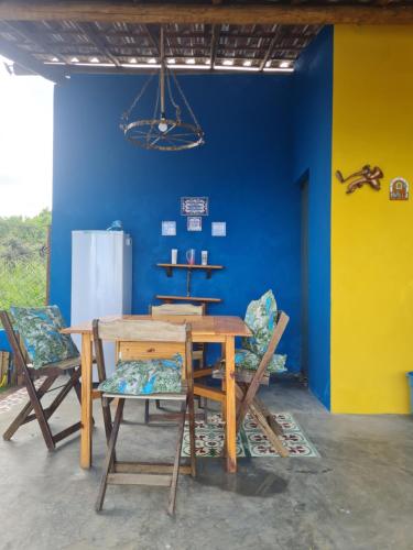 a dining room with a wooden table and chairs at Village as casinhas in Uruçuca
