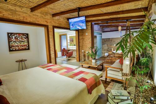 um quarto com uma cama e uma sala de estar em Cabanas Portal da Serra em Mogi das Cruzes