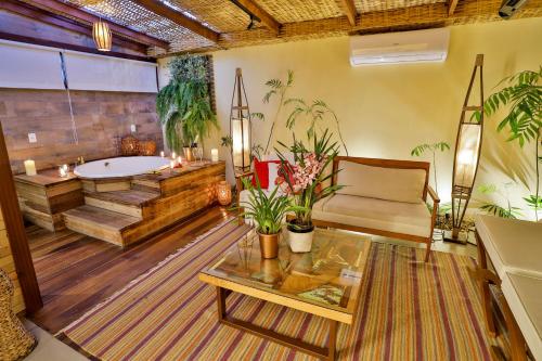 uma sala de estar com uma banheira, um sofá e uma mesa em Cabanas Portal da Serra em Mogi das Cruzes