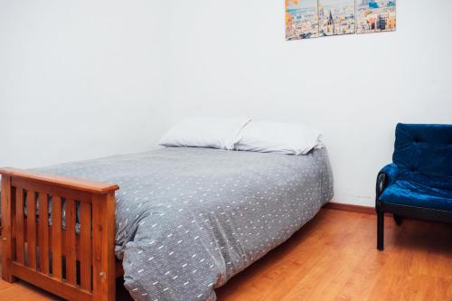 1 dormitorio con 1 cama y 1 silla azul en Gorriti 3744 Pet & 420 Friendly en Buenos Aires