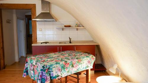 a kitchen with a table with a flowered table cloth at Holiday House Mária in Závažná Poruba