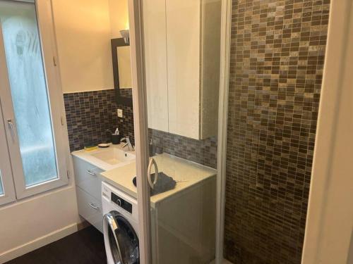 ein Badezimmer mit einem Waschbecken und einer Waschmaschine in der Unterkunft Saint ouen: superbe appartement in Saint-Ouen