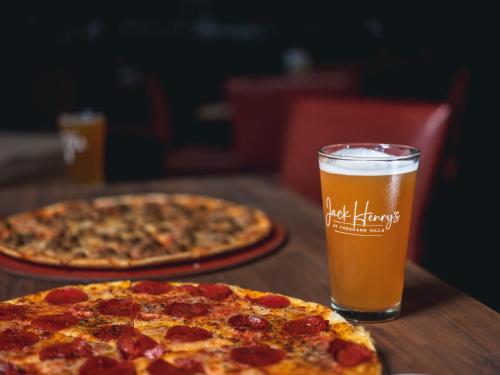 two pizzas on a wooden table with a glass of beer at Thousand Hills Resort Hotel in Branson