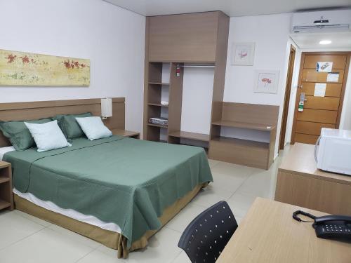 a bedroom with a bed and a desk and a table at Apto Hotel Blue Tree Manaus in Manaus