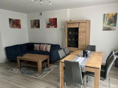 a living room with a blue couch and a table at Mieszkanie - Apartament in Dąbrowa