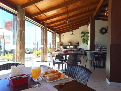 a restaurant with a table with a glass of orange juice at Hotel San Felipe in Sucre