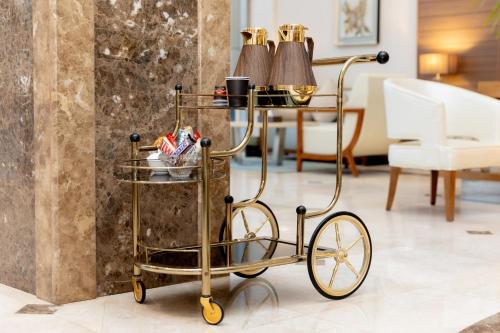 a gold metal cart with two lamps on top at أيام للشقق المخدومة in Buraydah