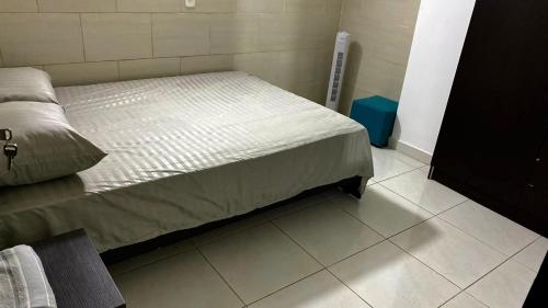 ein Schlafzimmer mit einem Bett und Fliesenboden in der Unterkunft Apartamento cerca helipuerto angar M45 Azotea in Medellín