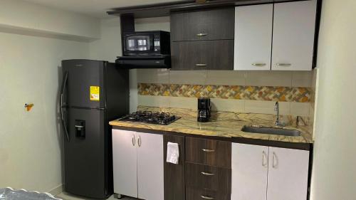eine kleine Küche mit Kühlschrank und Spüle in der Unterkunft Apartamento cerca helipuerto angar M45 Azotea in Medellín