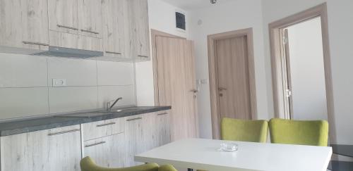 a kitchen with a table and two green chairs at Villa Ronić in Soko Banja
