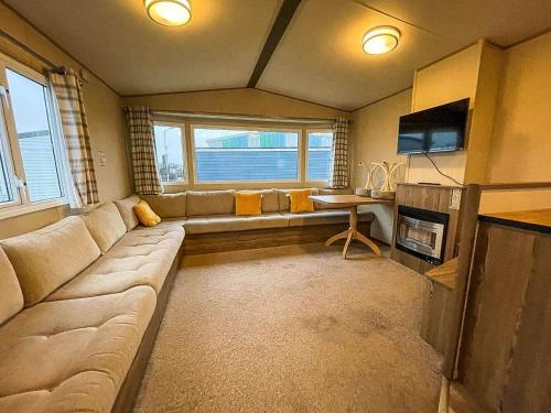 a living room with a large couch and a table at Seawick Caravan 922 in Clacton-on-Sea