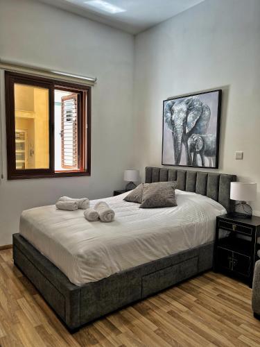 1 dormitorio con 1 cama grande y 2 toallas. en Cozy house city center in Limassol en Limassol
