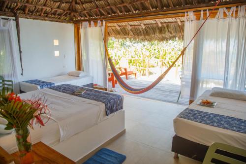 a bedroom with two beds and a view of a porch at Hotel Isla Del Pirata in Isla del Pirata