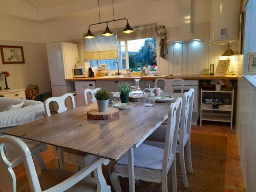 a kitchen and dining room with a wooden table and chairs at Quinta da Maínha - Charming Houses - Escape to Nature in Braga