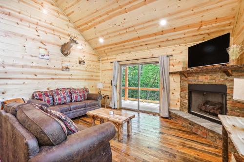 a living room with a couch and a fireplace at Private Murphy Cabin Rental with Wraparound Porch! in Murphy