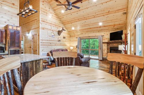 a log cabin kitchen and living room with a table at Private Murphy Cabin Rental with Wraparound Porch! in Murphy