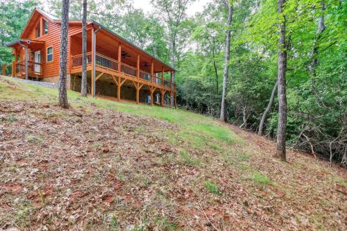 a large wooden house on a hill in the woods at Private Murphy Cabin Rental with Wraparound Porch! in Murphy
