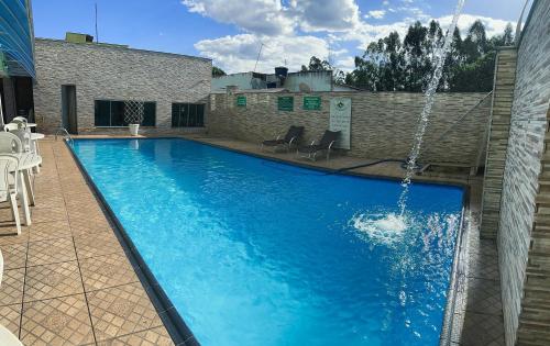 a large blue swimming pool with a fountain at Hotel Anápolis in Anápolis