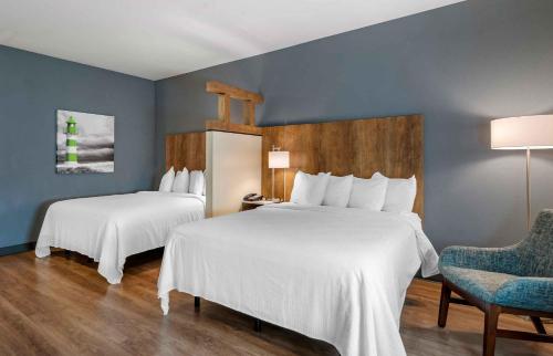 a hotel room with two beds and a chair at Extended Stay America Suites - Huntsville - Madison in Madison