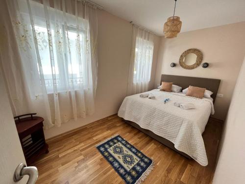 a bedroom with a bed and a large window at Fortunella Apartments in Herceg-Novi