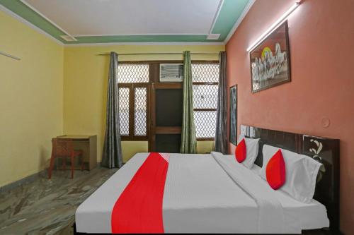 ein Schlafzimmer mit einem großen Bett mit roten und weißen Kissen in der Unterkunft OYO Flagship 81046 Royal Retreat in Gurgaon