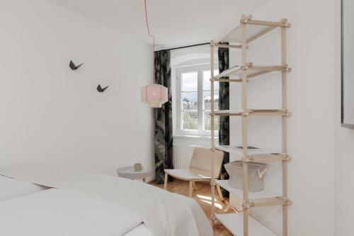 ein Schlafzimmer mit Bücherregal neben einem Bett in der Unterkunft Das Grüne Haus - Boutique Apartments ecofriendly in Innsbruck
