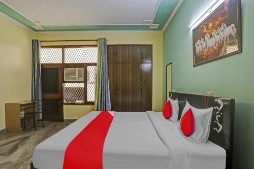 ein Schlafzimmer mit einem großen Bett mit roten Kissen in der Unterkunft OYO Flagship 81046 Royal Retreat in Gurgaon