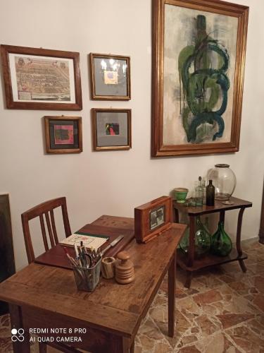a room with a wooden table with a picture on the wall at D'OR DUBLE' bed and breakfast in Carignano