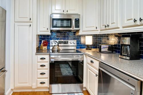 a kitchen with white cabinets and a stove top oven at Surfside Beach Condo with Ocean Access and Balcony! in Myrtle Beach