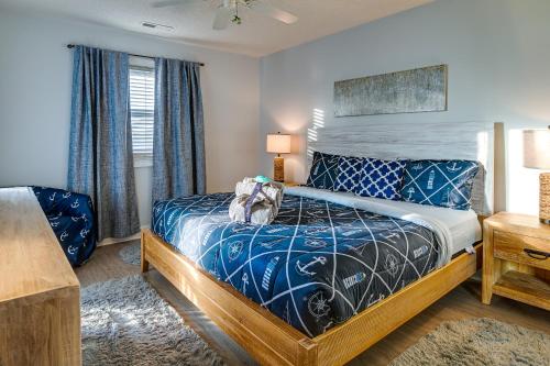 a bedroom with a bed with a blue comforter at Surfside Beach Condo with Ocean Access and Balcony! in Myrtle Beach