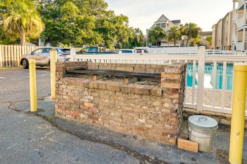 a brick wall next to a fence and a pool at Surfside Beach Condo with Ocean Access and Balcony! in Myrtle Beach