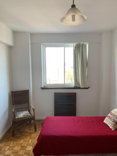 1 dormitorio con cama roja y ventana en Encantador & Amplisimo Depto en Buenos Aires