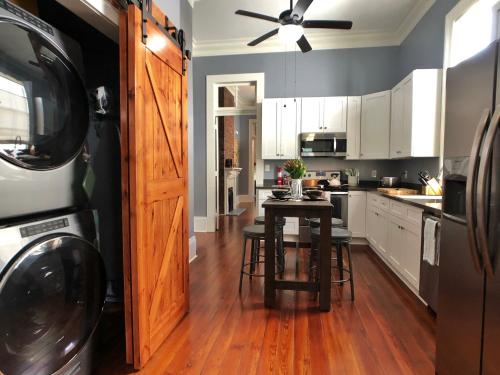 cocina con mesa y lavadora en Luxury Historic Shotgun Home in Lower Garden District en Nueva Orleans