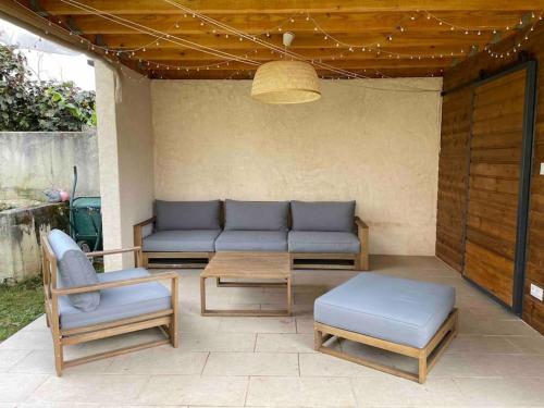 eine Terrasse mit einem Sofa, einem Tisch und Stühlen in der Unterkunft Maison de ville avec jardin dans impasse calme - idéal famille de 4 in Bourg-de-Péage