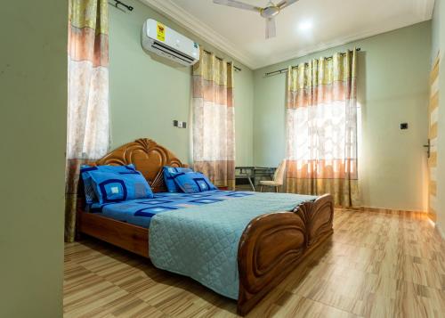 een slaapkamer met een bed met een blauw dekbed bij NKA Properties in Apenkwa
