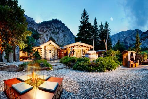 una casa de madera con una mesa delante en Gramai Alm alpengenuss & natur spa, en Pertisau