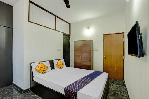 1 dormitorio con 1 cama con almohadas amarillas y azules en SPOT ON Sri Durga Residency Hd Kote, en Mysore