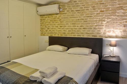 a bedroom with a bed with towels on it at Duplex moderno en Alameda in Seville