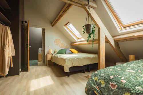 ニーウポールトにあるHHVDK city loftのベッドと天窓のある屋根裏部屋の寝室