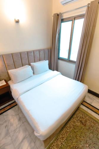 un grande letto in una stanza con finestra di Renaissance Hotels a Islamabad