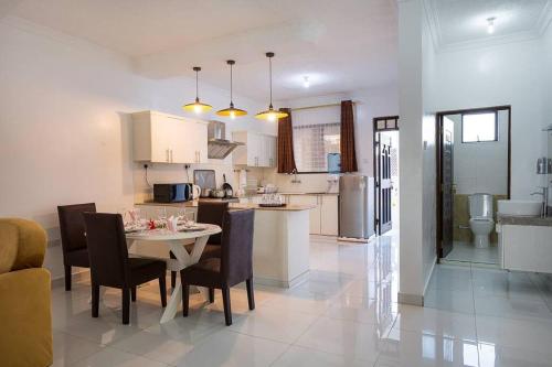 a kitchen and dining room with a table and chairs at Villa Becky - Diani Beach in Diani Beach
