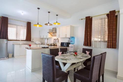 a kitchen and dining room with a table and chairs at Villa Becky - Diani Beach in Diani Beach