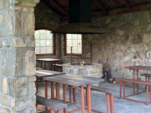 un grupo de mesas de picnic en un edificio de piedra en Penzión Hrubjak, en Oravská Polhora